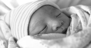 Imagem de bebê recém nascido - pai com a declaração de nascido vivo em mãos