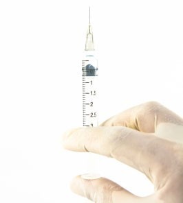 Mão de profissional da saúde preparando a injeção - Vacinas para viajantes